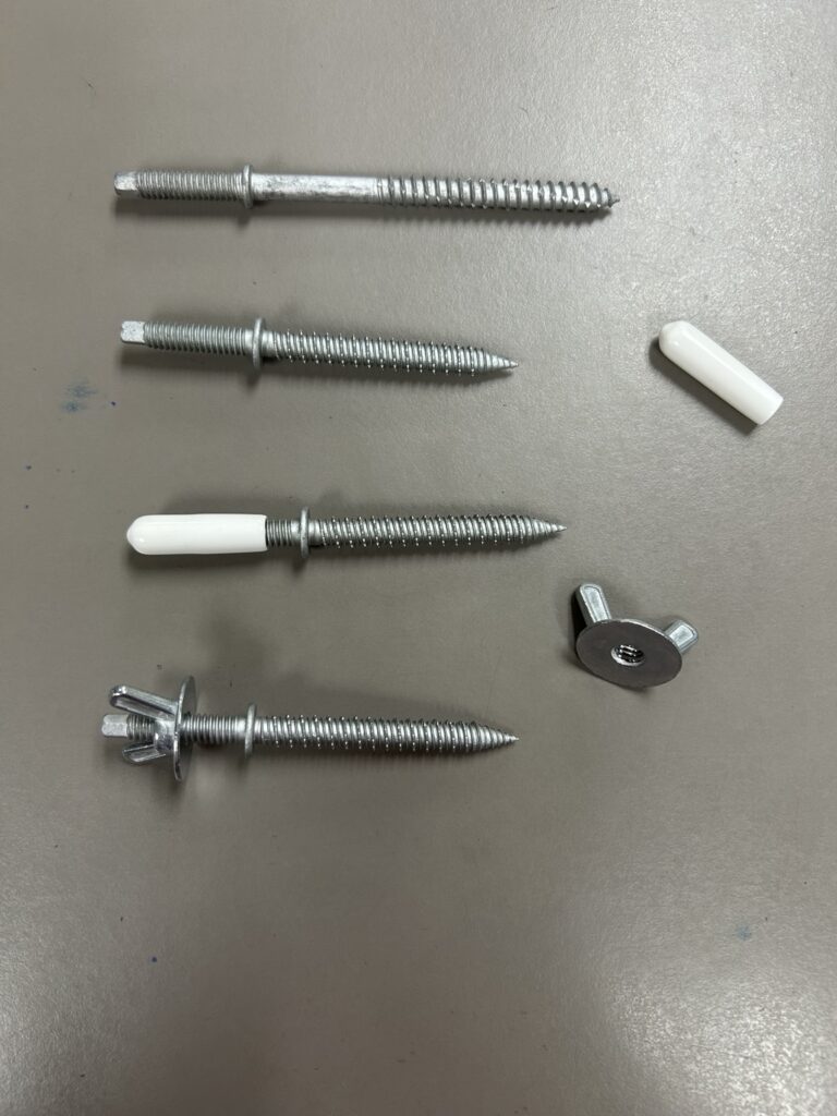 Assorted storm-panel fasteners, threaded studs, wing nuts and white protective caps