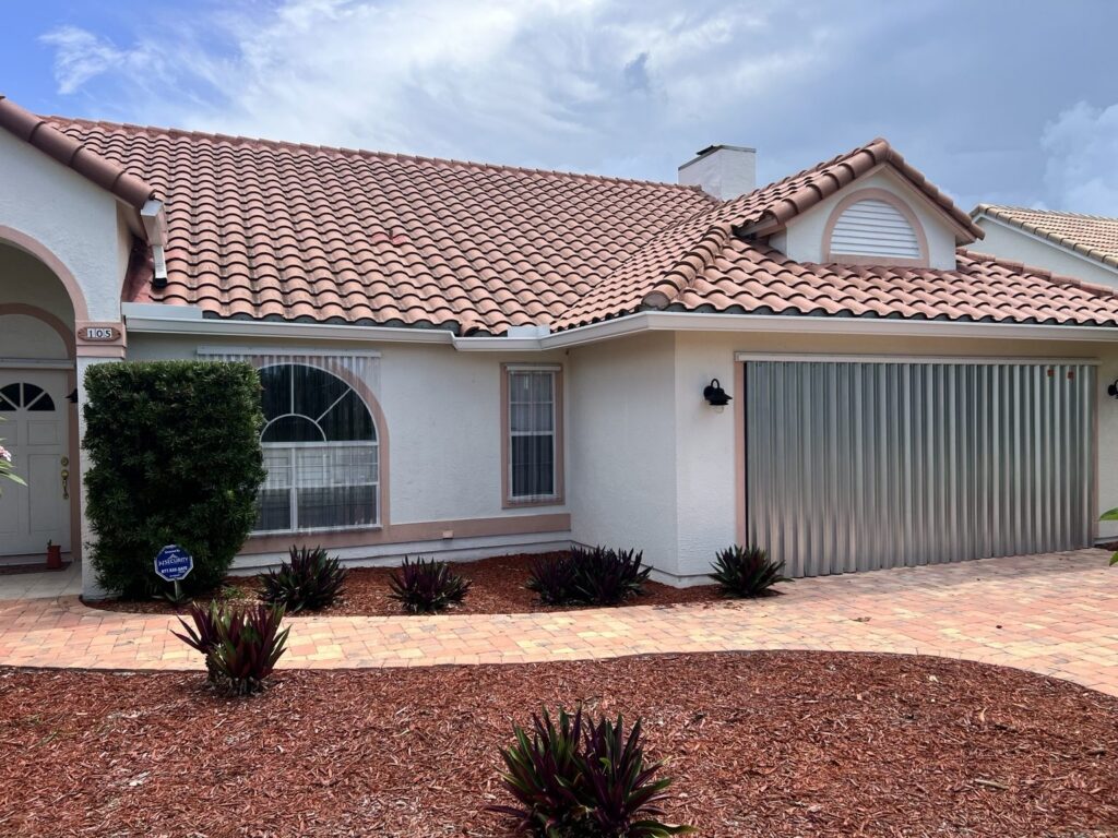 Aluminum storm panels over a garage opening with clear Lexan panels over nearby windows
