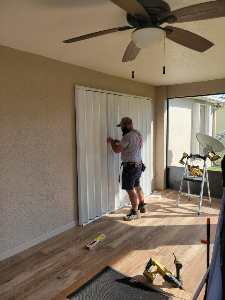HSPM installer adjusting an accordion hurricane shutter during installation