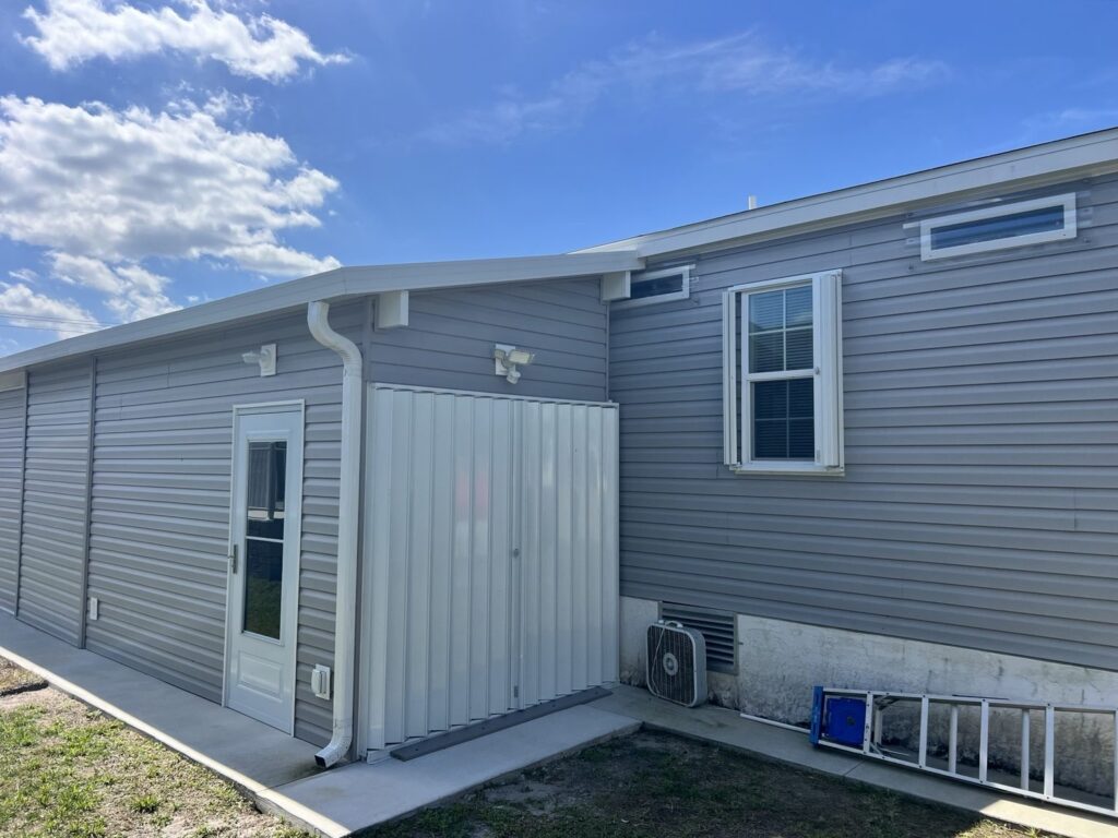 Accordion shutter installed across a wide opening on a manufactured home