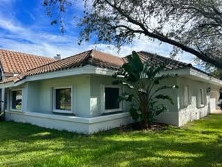 Same Florida home with accordion shutters stacked open beside the openings