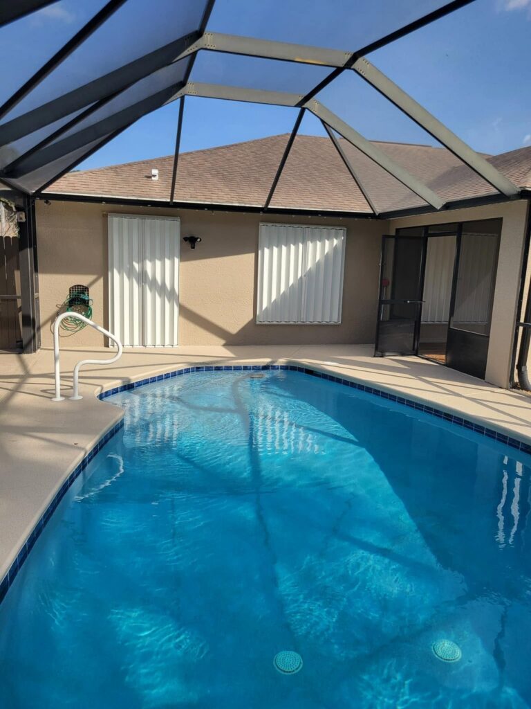 White accordion shutters protecting openings around a screened pool area