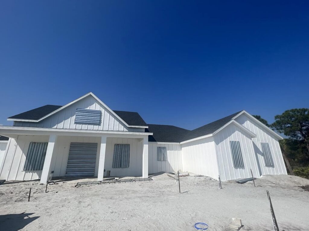 Removable metal storm panels installed on a white new-construction Florida home