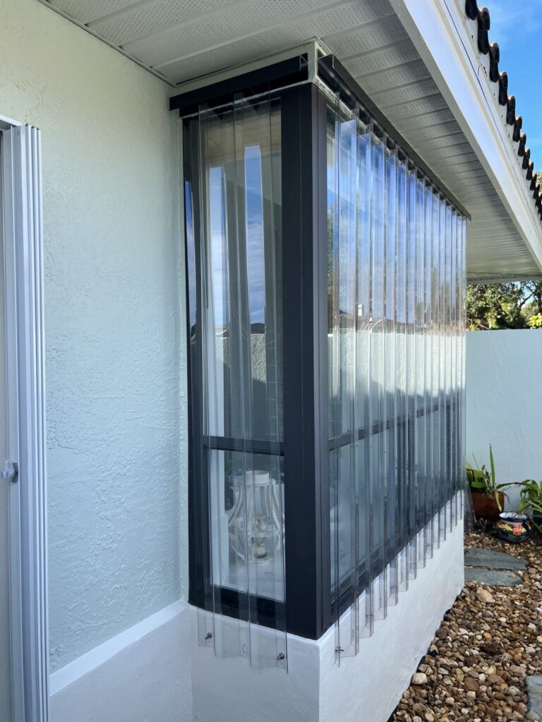 Clear Lexan storm panels installed around a corner window