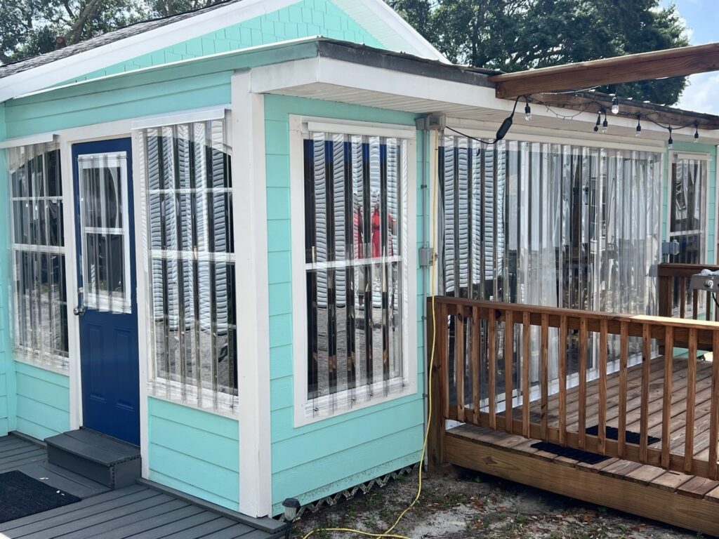 Clear Lexan storm panels installed around a turquoise Florida sunroom